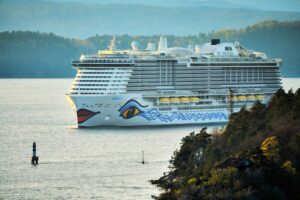 Photo by Vidar Nordli-Mathisen a large cruise ship in a body of water
